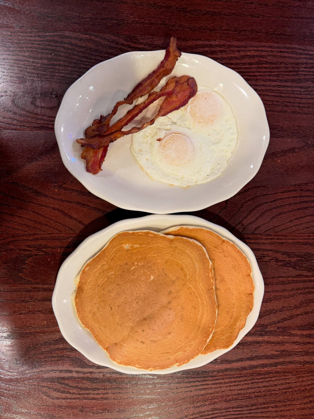 Bacon, eggs over easy, and a stack of pancakes