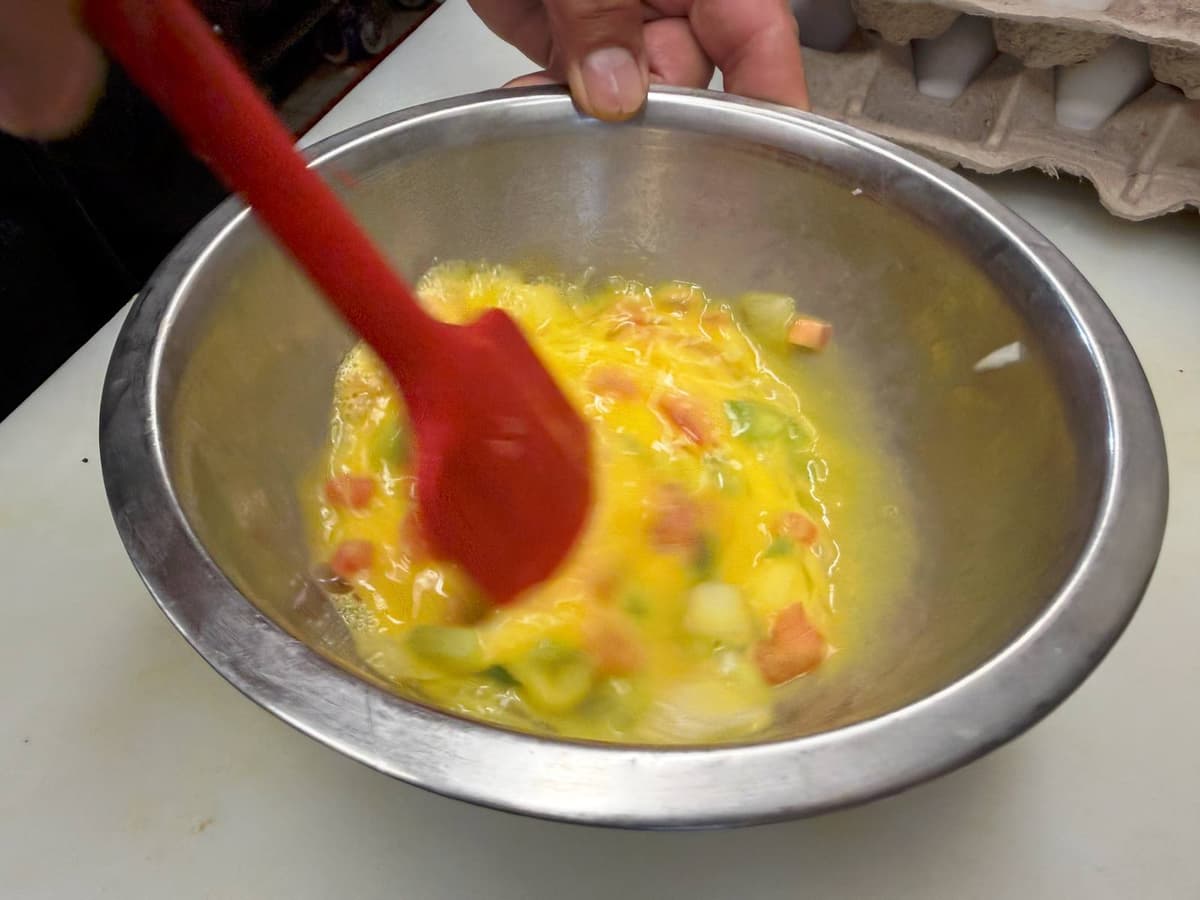 Mixing eggs by hand in a steel bowl