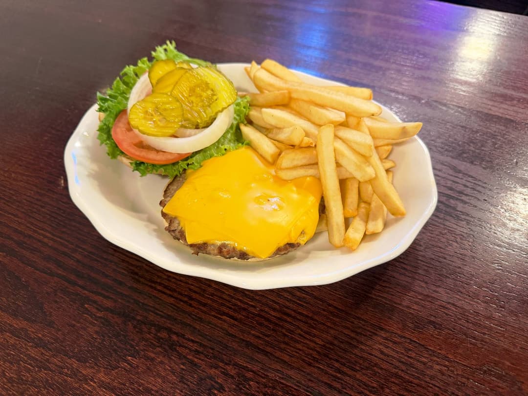 Cheeseburger with french fries, lettuce, tomato, onion, and pickles
